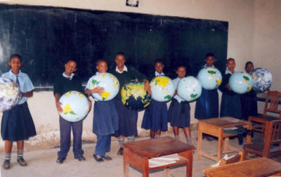 students holding inflatable globes in a classroom